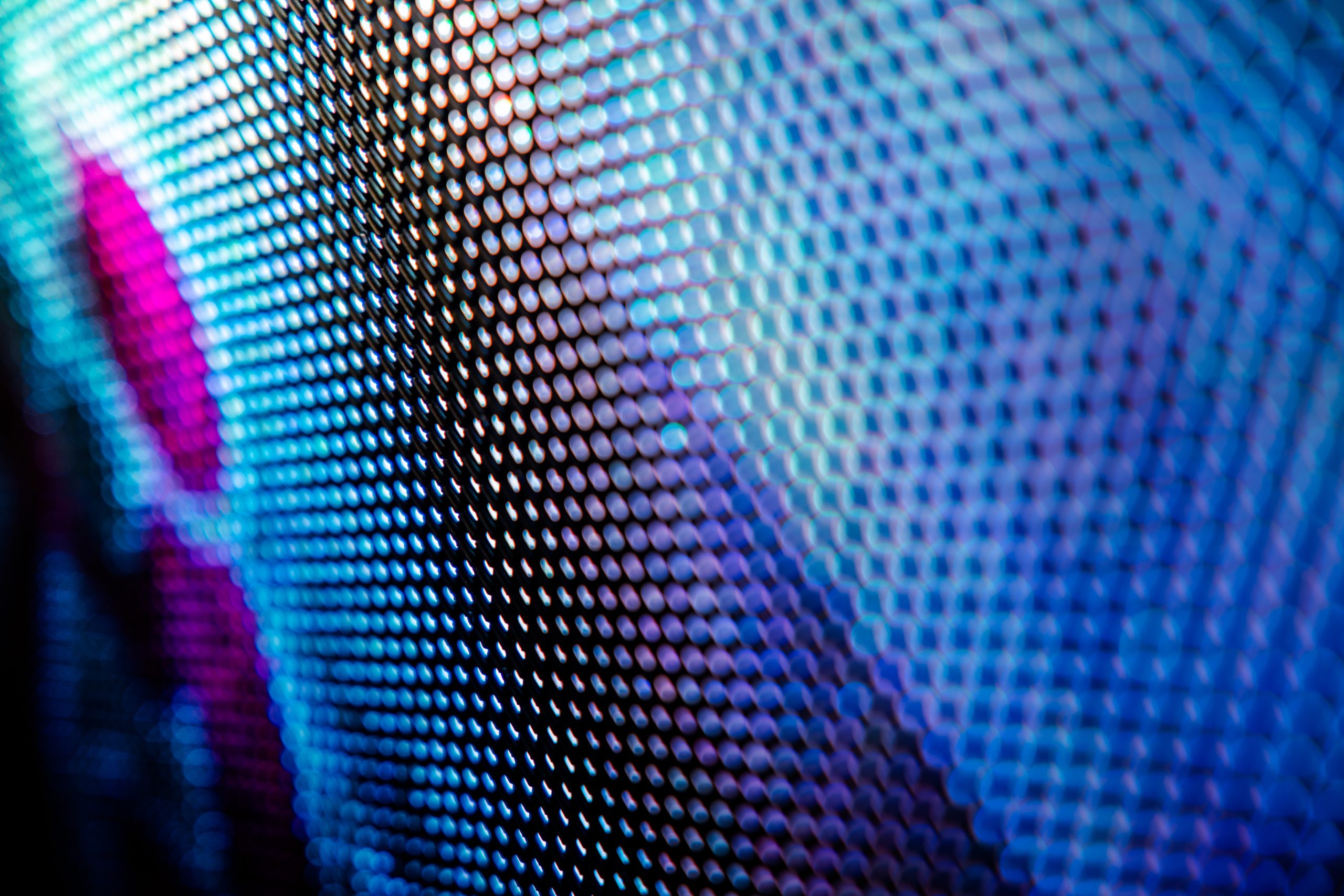 Close-up of a LED screen displaying vibrant blue and purple dot patterns creating an abstract, colorful texture.