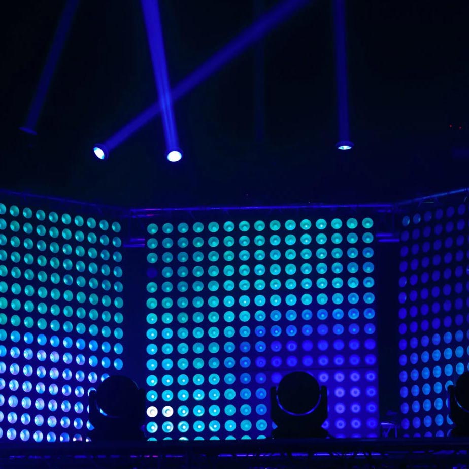 LED Video Wall - Day And Night Inc, San Diego, CA. Blue and green LED stage lights with spotlights shining overhead in a dark setting.